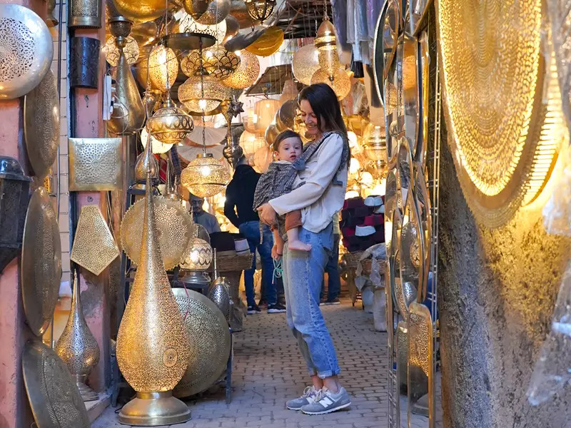 Mujer y su bebé de turismo por Marrakech en un mercado típico - Agencia de viajes Mi Viajazo